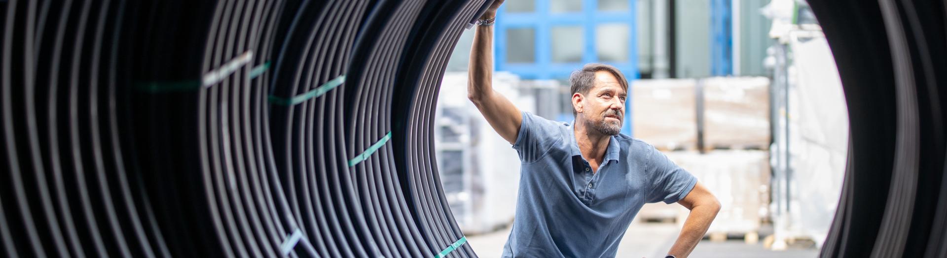 Mann blickt durch Abwasserrohre