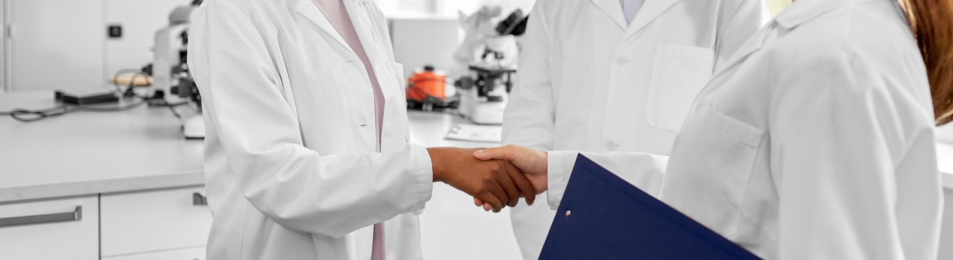 zwei Forscherinnen reichen sich die Hand
