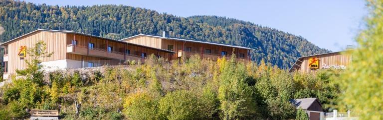 Seitenansicht Hotel mit Holzwänden umgeben von Wald