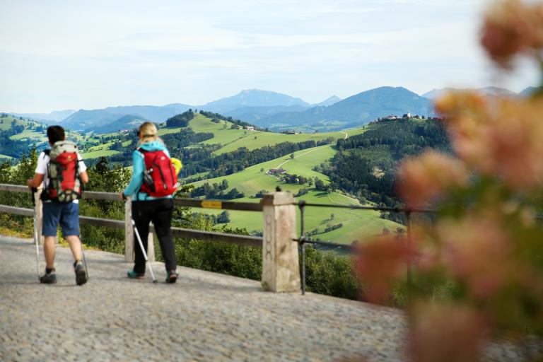 zwei Personen gehen wandern auf einem Betonweg