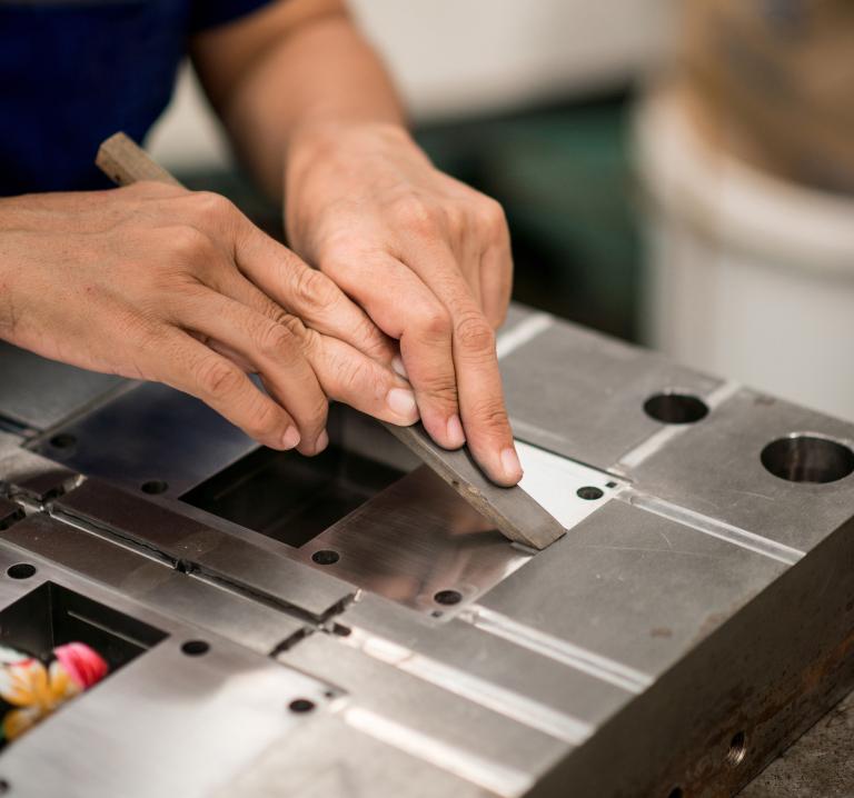 Mann arbeitet an einem Werkstück im Werkzeugbau