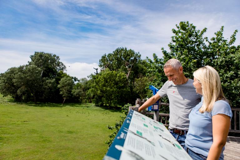 Ein Paar beim Betrachten der Storchhaus Marchegg Infotafeln