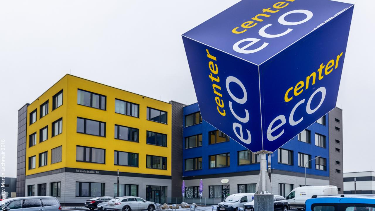 ecocenter Würfel Wolkersdorf vor blau-gelben Gebäude mit Parkplätzen im Schnee