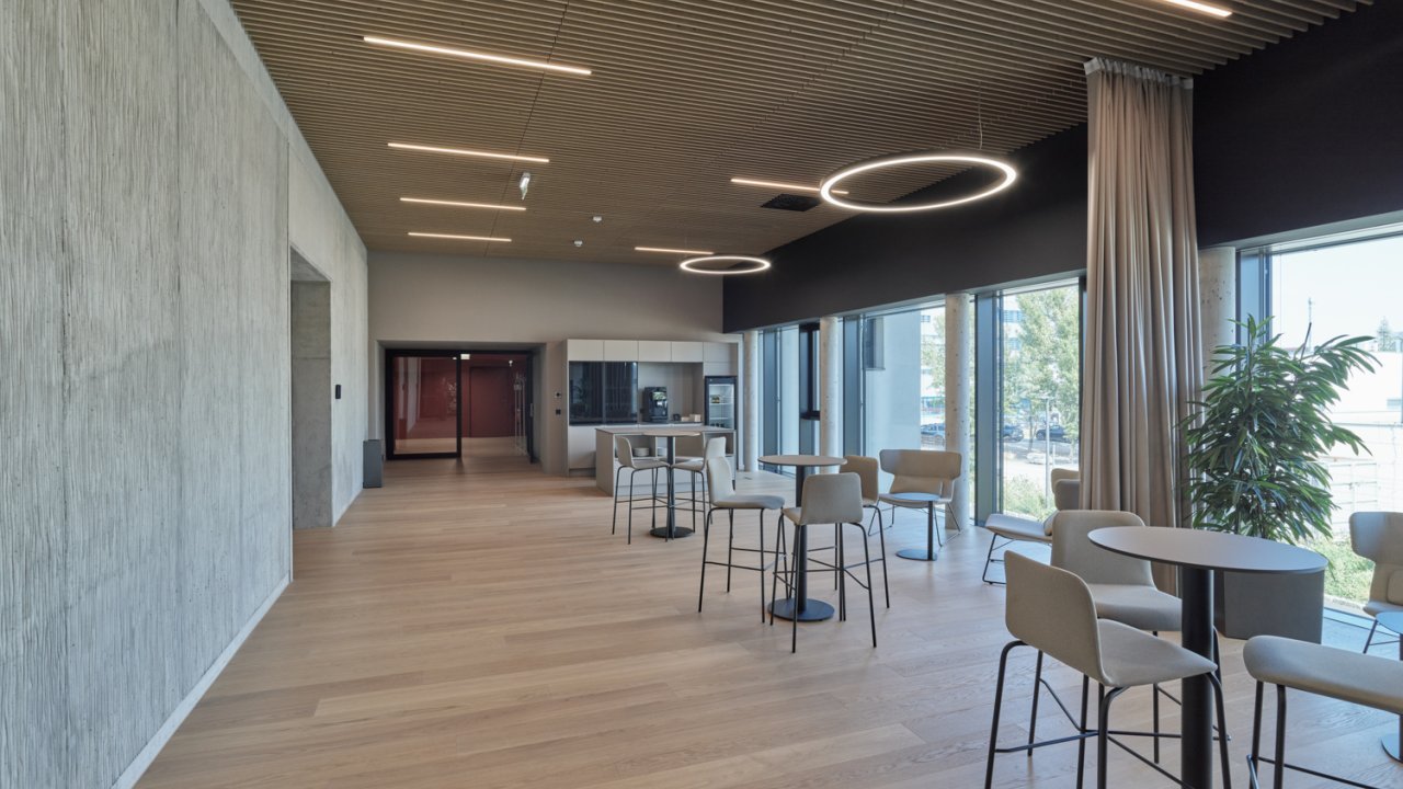 Foyer einer modernen Veranstaltungslocation mit Stehtischen und einer Küchenzeile im Hintergrund