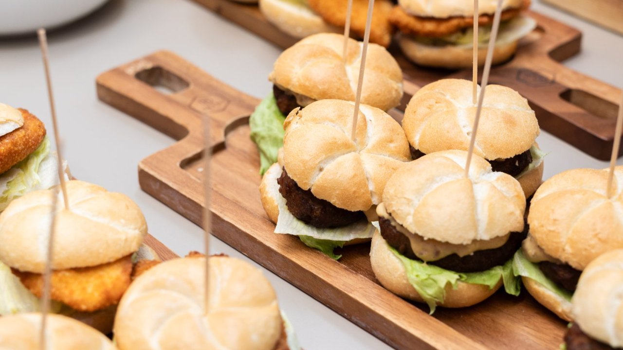 Kleine Burger- und Schnitzelsemmeln bei einem Buffet auf Holzbrettern