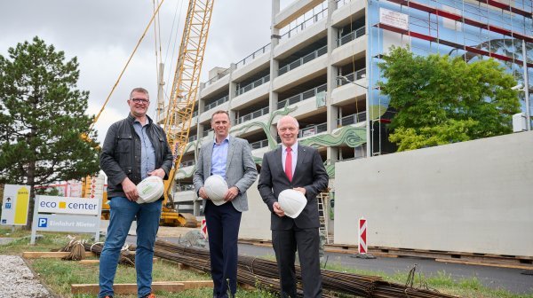Drei Männer stehen vor Parkhaus Baustelle