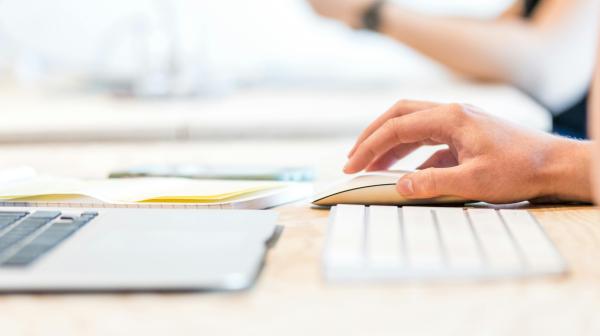 ein Laptop, eine Tastatur und eine Computermaus sind auf einem Tisch