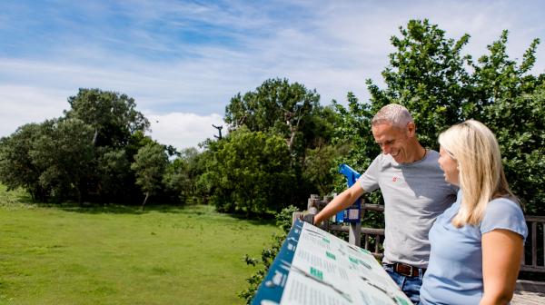 Ein Paar beim Betrachten der Storchhaus Marchegg Infotafeln