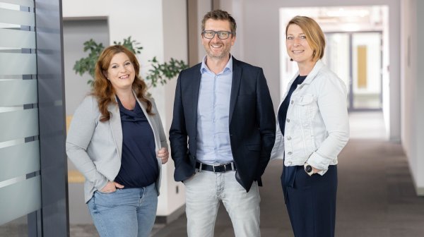 Drei Personen in modernem Büroambiente