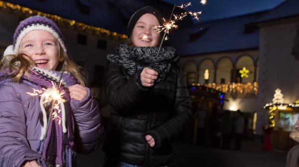 zwei Kinder lachen mit Sternspritzer in die Kamera 