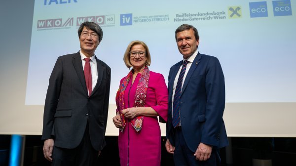 drei Personen stehen nebeneinander und lachen in die Kamera