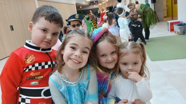 Vier verkleidete IZIBIZI Kinder in der Aula