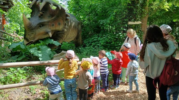 Kleine Kindergartenkinder bestaunen das große Dino-Modell 