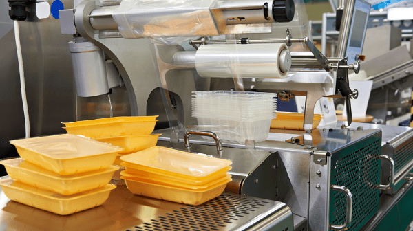 Automatisierte Verpackungsanlage mit Kunststoffschalen und Folie
