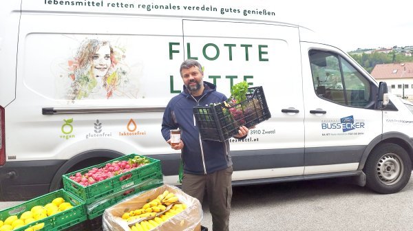 Man mit Lebensmittel-Kiste von kleinem Liefervan