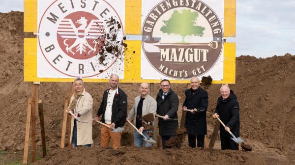 Sechs Personen mit Schaufeln beim Spatenstich der Baustelle