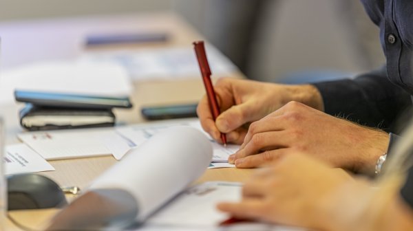 Fortbildungsszene an einem Tisch mit Papierunterlagen