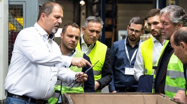 Person zeigt anderen Personen einen Gegenstand