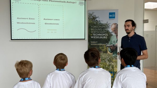 Vier Kinder hören Vortragendem zu