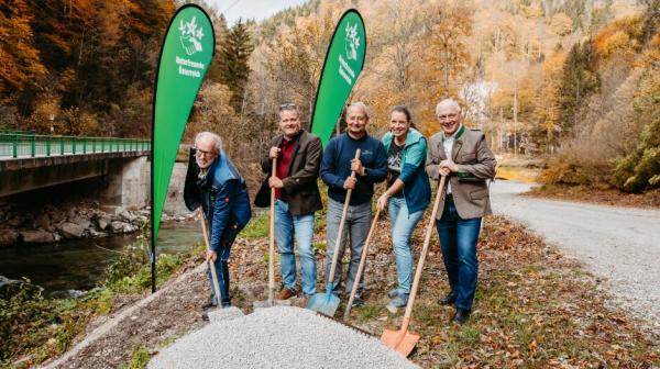 fünf Personen stehen nebeneinander mit einem Spaten in der Hand